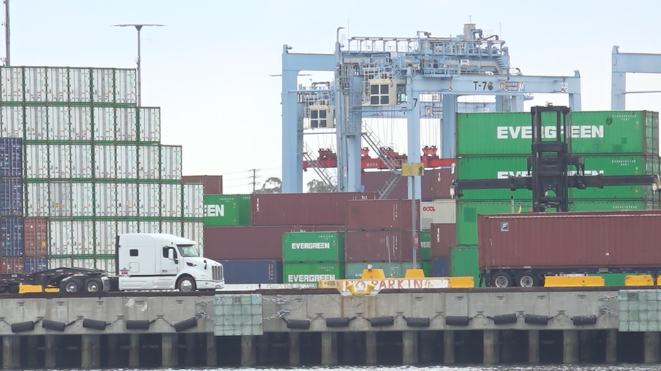 Trucks driving in front of Evergreen cargo containers